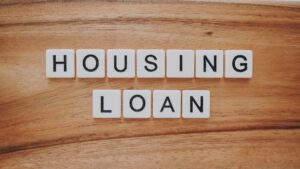 image of a graphic of letter tiles spelling out housing loan on a wood background for mortgage refinancing