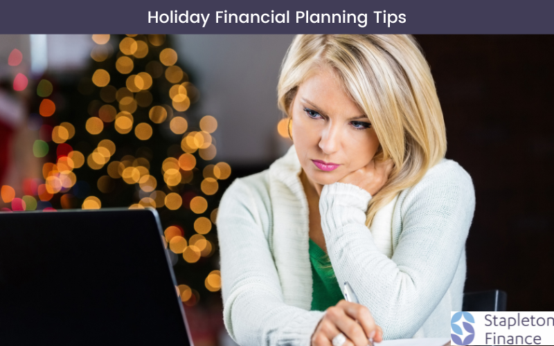 woman in a white cardigan and green shirt leaning on her hand and looking at her computer with a frown with a christmas tree in the background for holiday financial planning