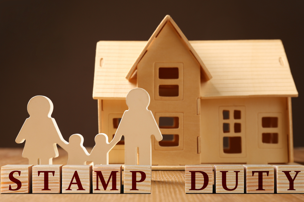 image of a small wooden house with a wooden cut out family with stamp duty blocks in front for first home guarantee scheme qld