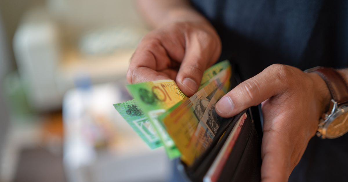 close up of a hand taking Australian money out of a brown wallet for what's my borrowing power
