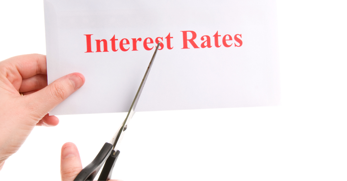 piece of paper with the words interest rates written on it with someone cutting it in half with scissors