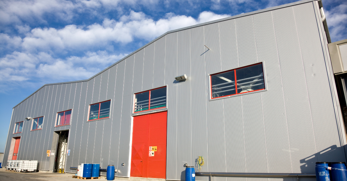 image of a grey warehouse with a bright red door