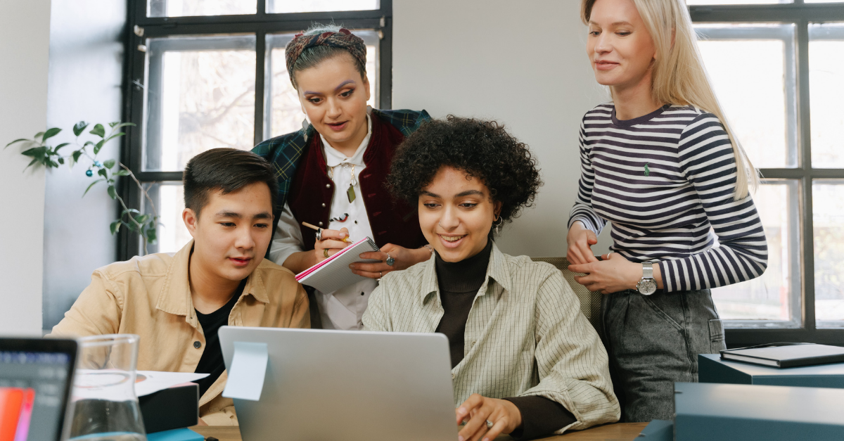 group of professional lenders sitting around a computer looking at income for sole traders and side hustles