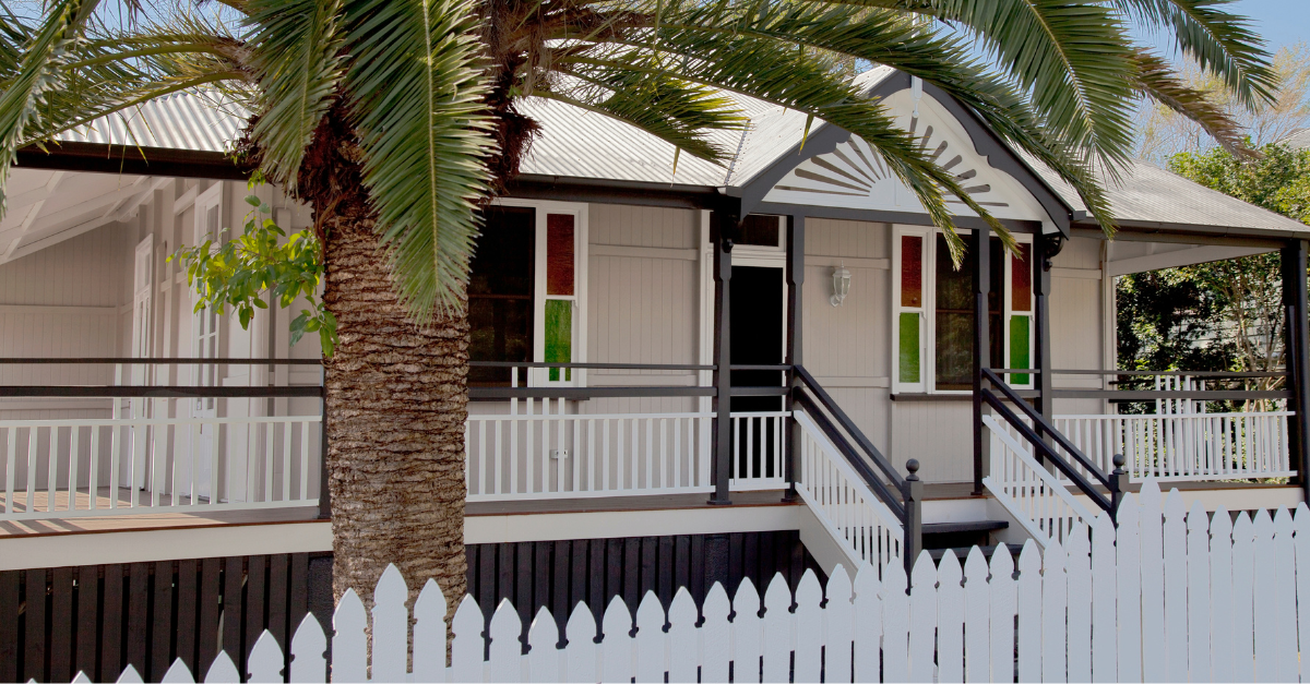 Queenslander home, white with green and green and red stained glass windows